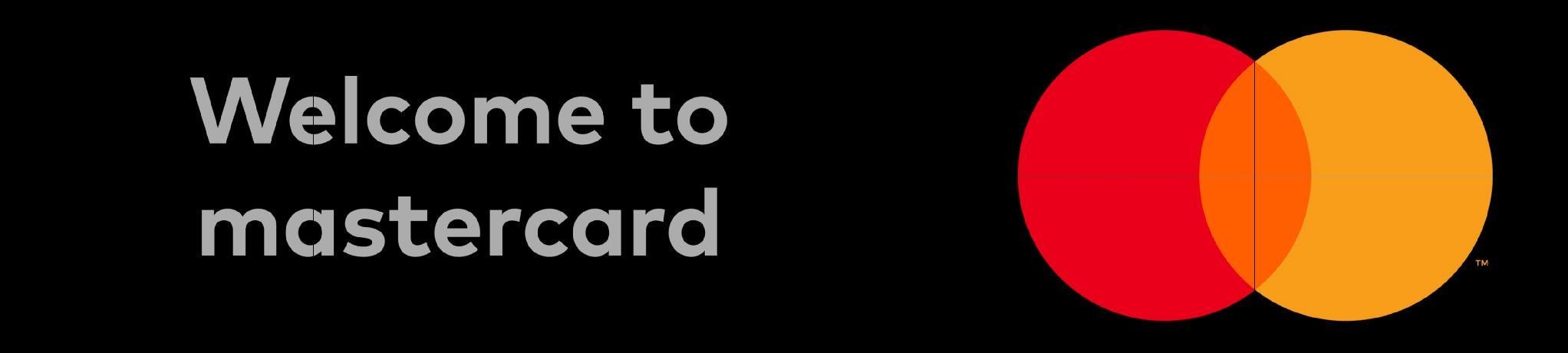 Storyboard frame: the words Welcome to mastercard in grey on the left of a black wall, the Mastercard mark on the right, mid fade